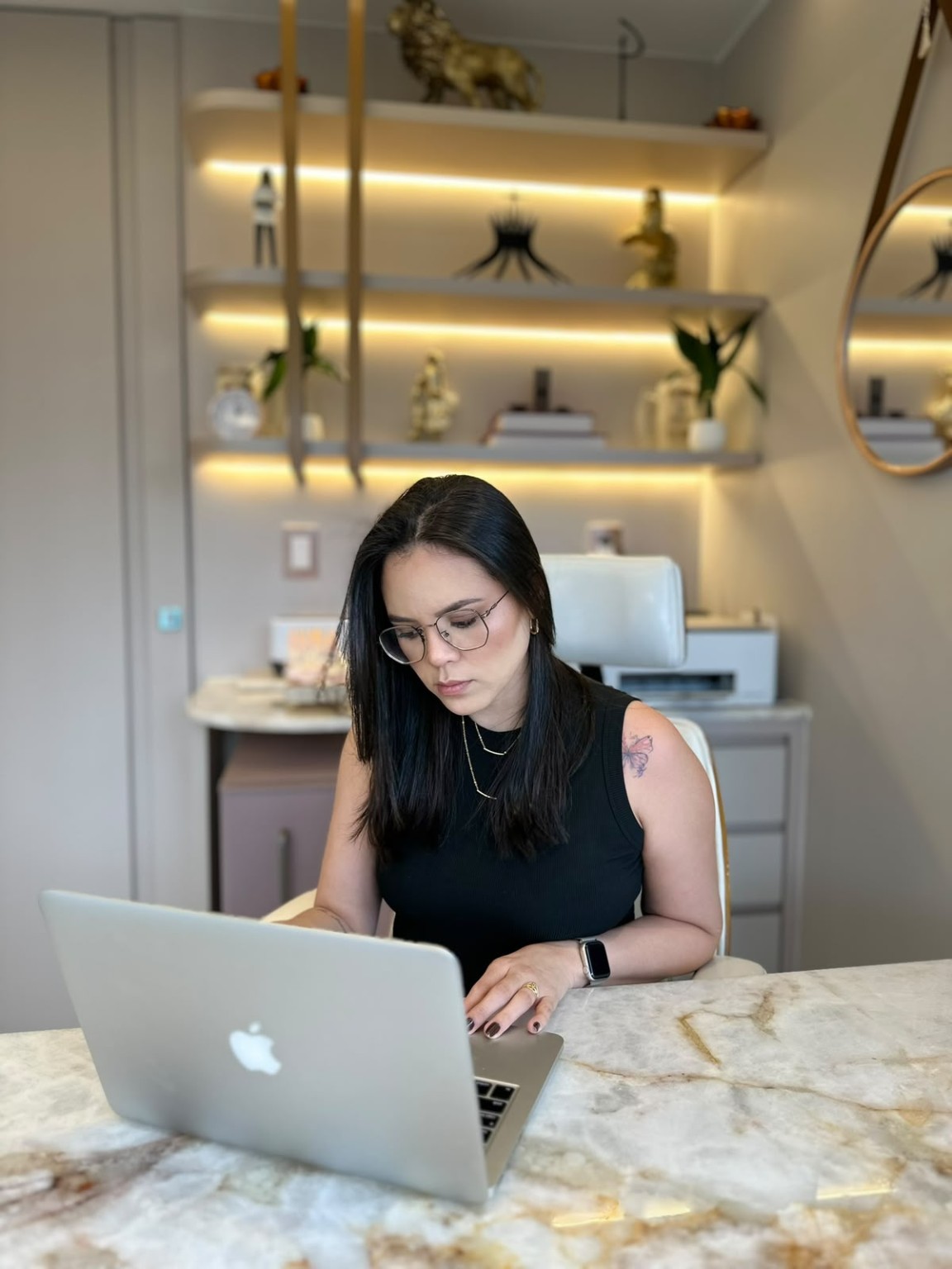 Irlanea Nascimento em seu ambiente de atendimento, utilizando um computador
